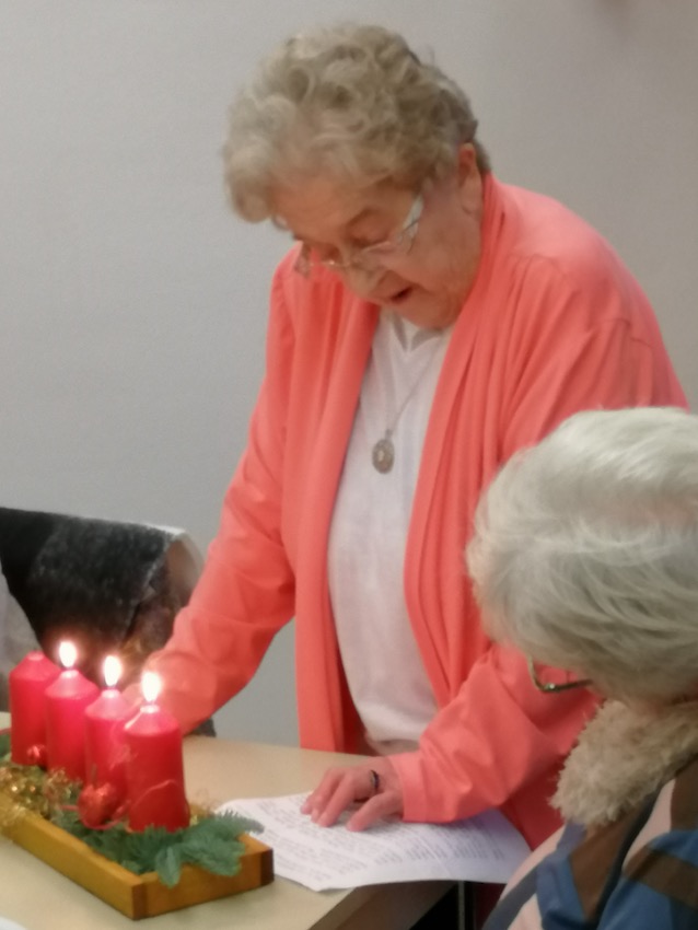 Lieselotte Tauber aus Ebergötzen trägt ein Gedicht über das hoffnungsvolle Licht einer Adventskerze vor. Foto: Caritas