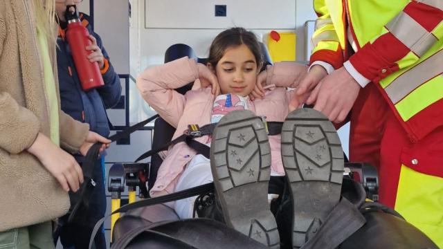 Das Probeliegen im Rettungswagen machte viel Spaß, richtiges Anschnallen muss geübt sein. | Foto: Caritas